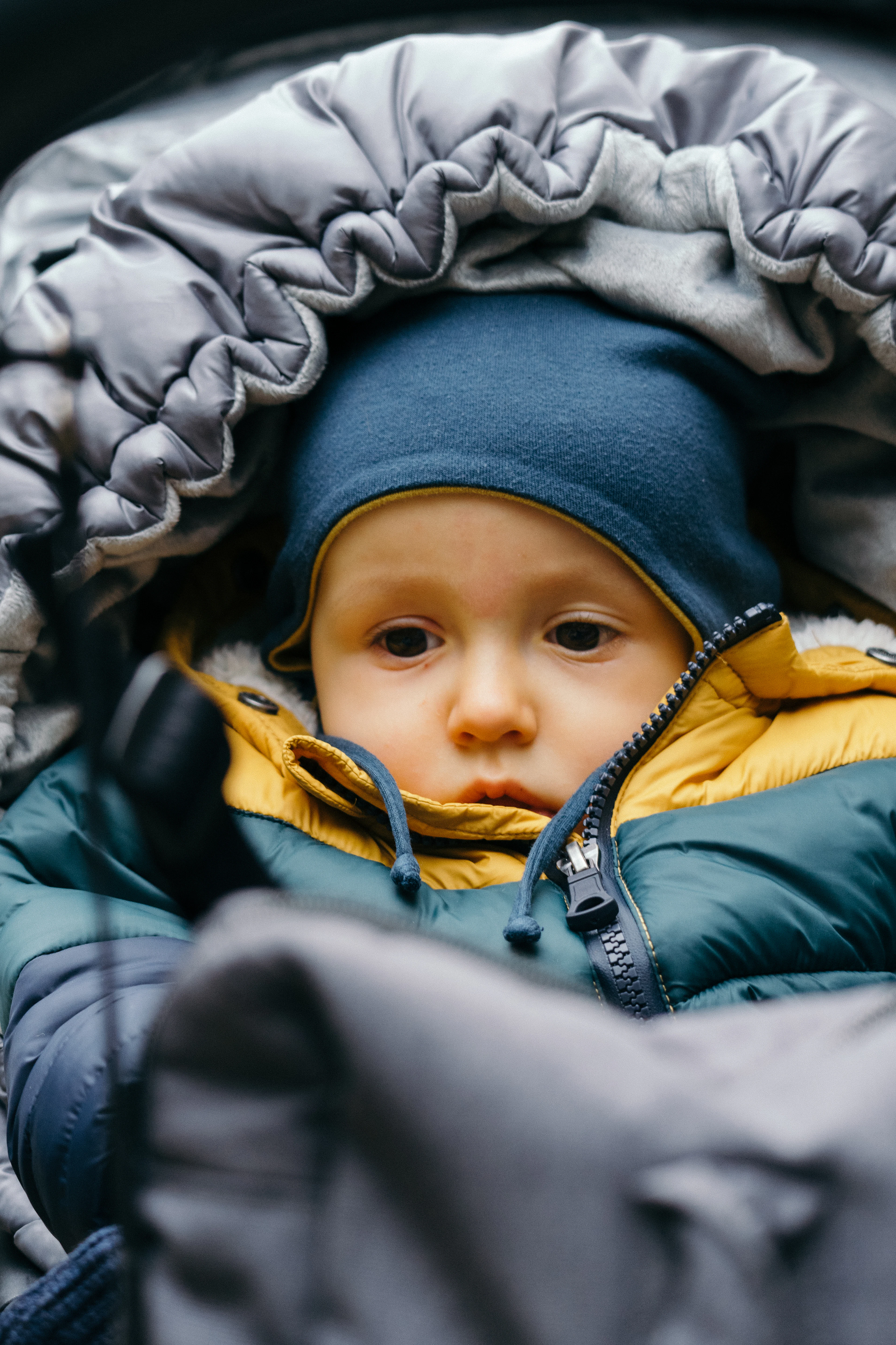 A baby bundled up in a puffy down layer
