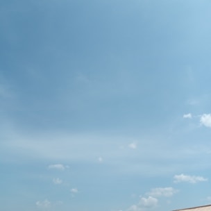 A clear blue sky above a commercial building showing newly repaired gutters.