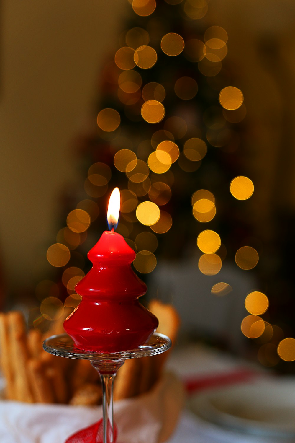 red candle on clear glass holder