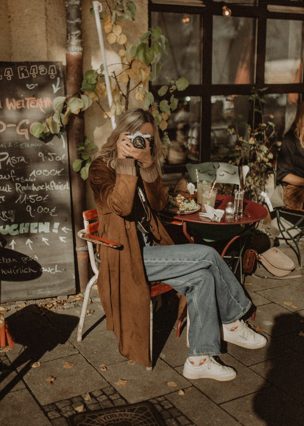 woman in brown coat sitting on chair