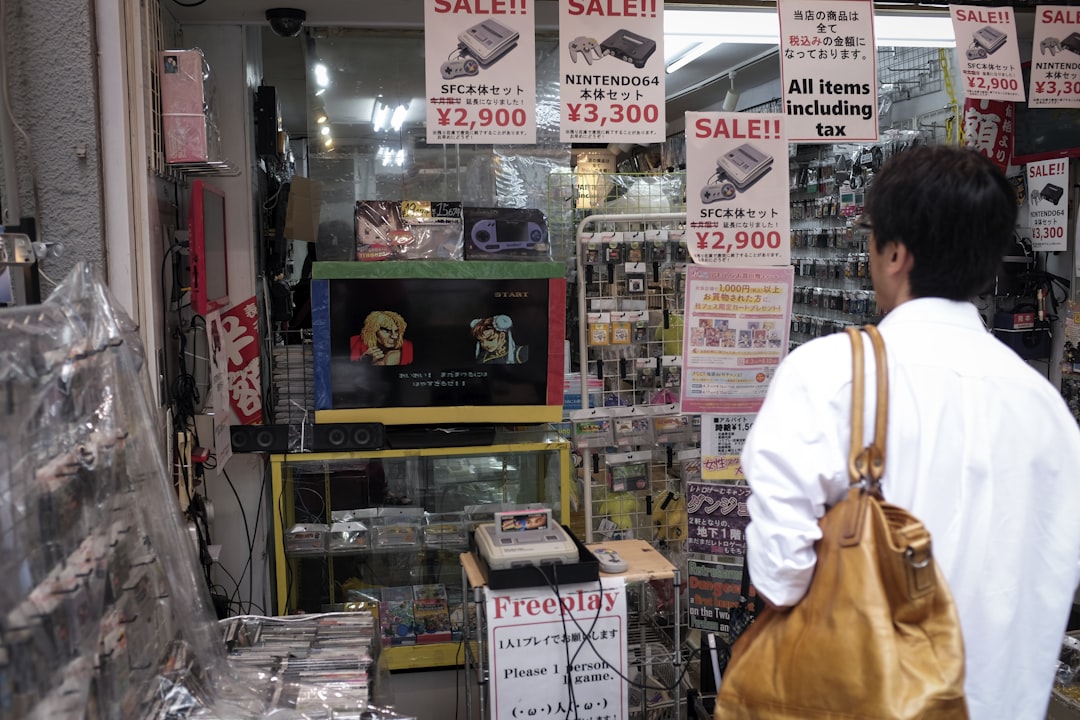 man in white dress shirt and brown pants standing near glass shelf, wandering around Akihabara, Tokyo - Japan.</p></figure><p>