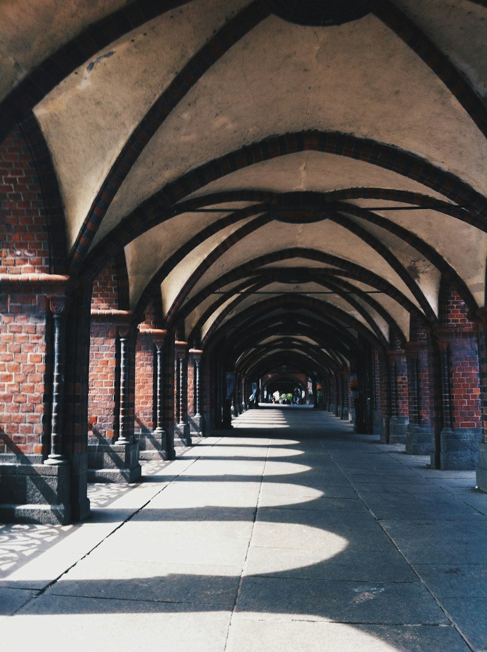a walkway lined with arches and benches on both sides of it
