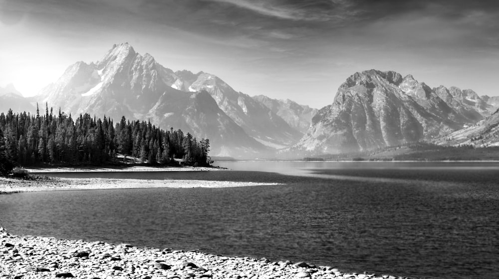 snow covered mountain near body of water during daytime