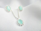 Bridal set featuring a shimmering necklace and matching earrings against a soft white background