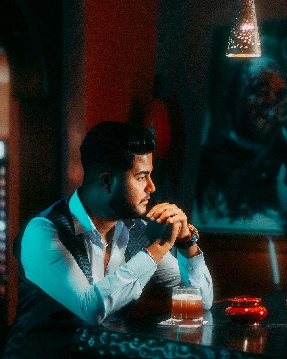 man in blue and white long sleeve shirt drinking from a glass