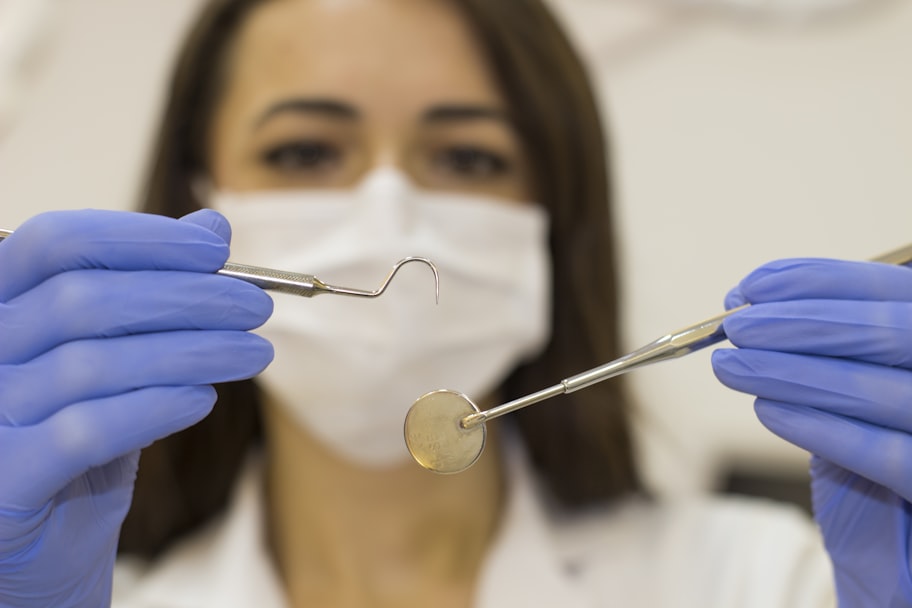 Dentist holding a periodontal probe and mirror during a gum health examination