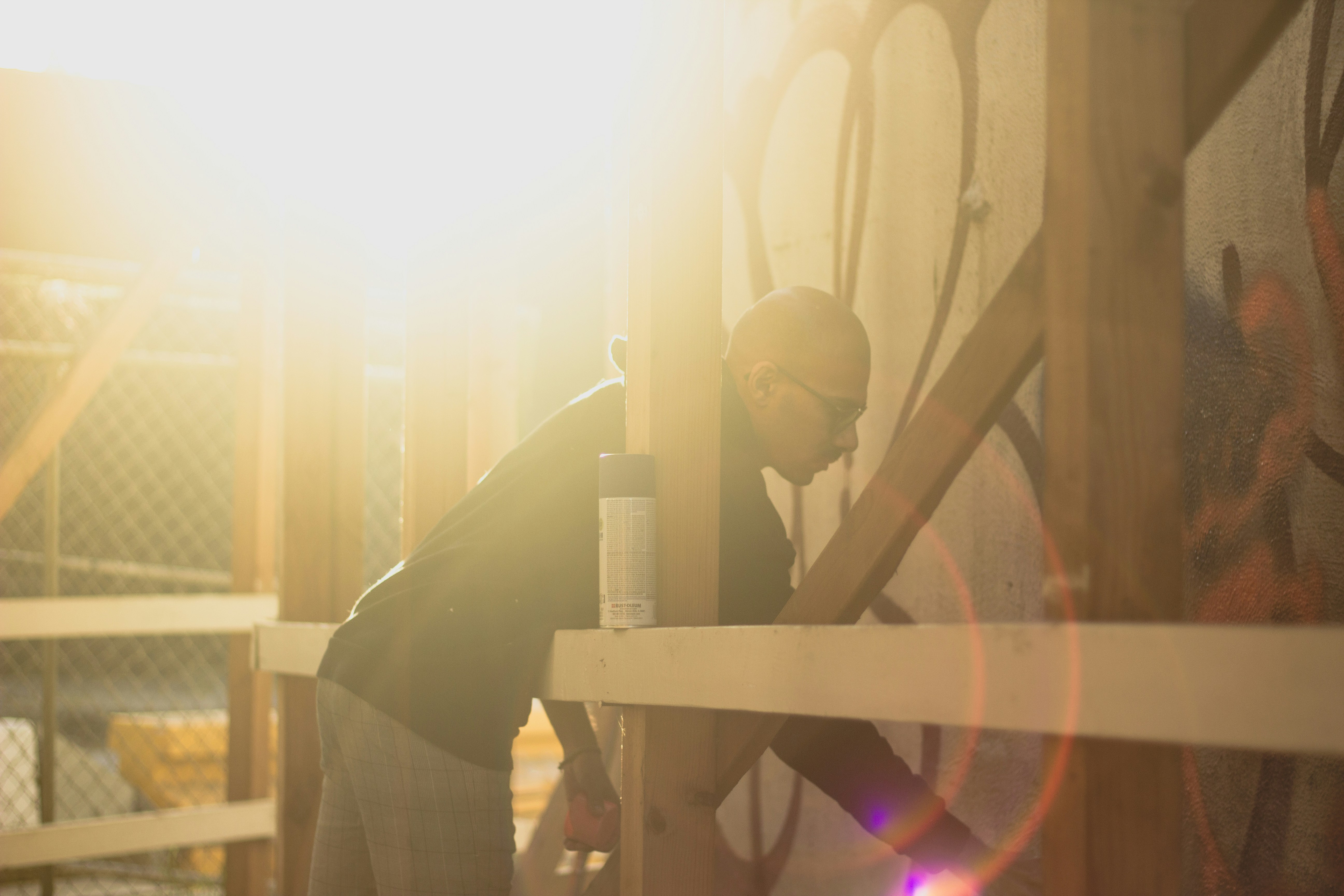 man in black jacket standing near brown wooden table