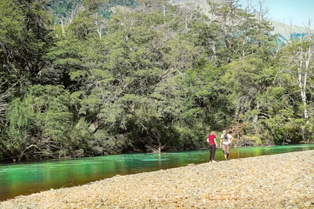 A serene riverside scene in Garut with travelers enjoying a guided nature walk.
