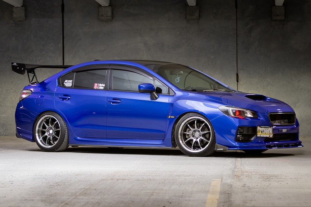 blue bmw m 3 coupe parked on gray concrete floor