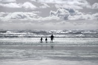 A family walking happily along a sunny beach during a cruise stop.