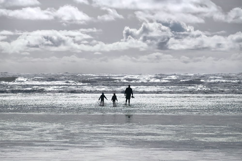 silhouette of 2 people walking on beach during daytime