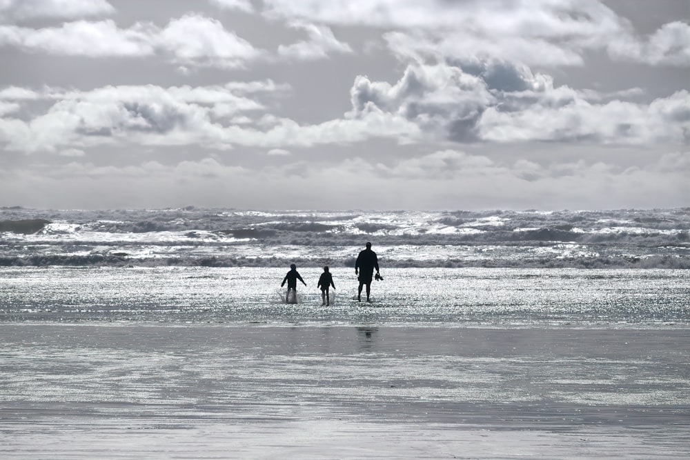 Silhouette von 2 Personen, die tagsüber am Strand spazieren gehen