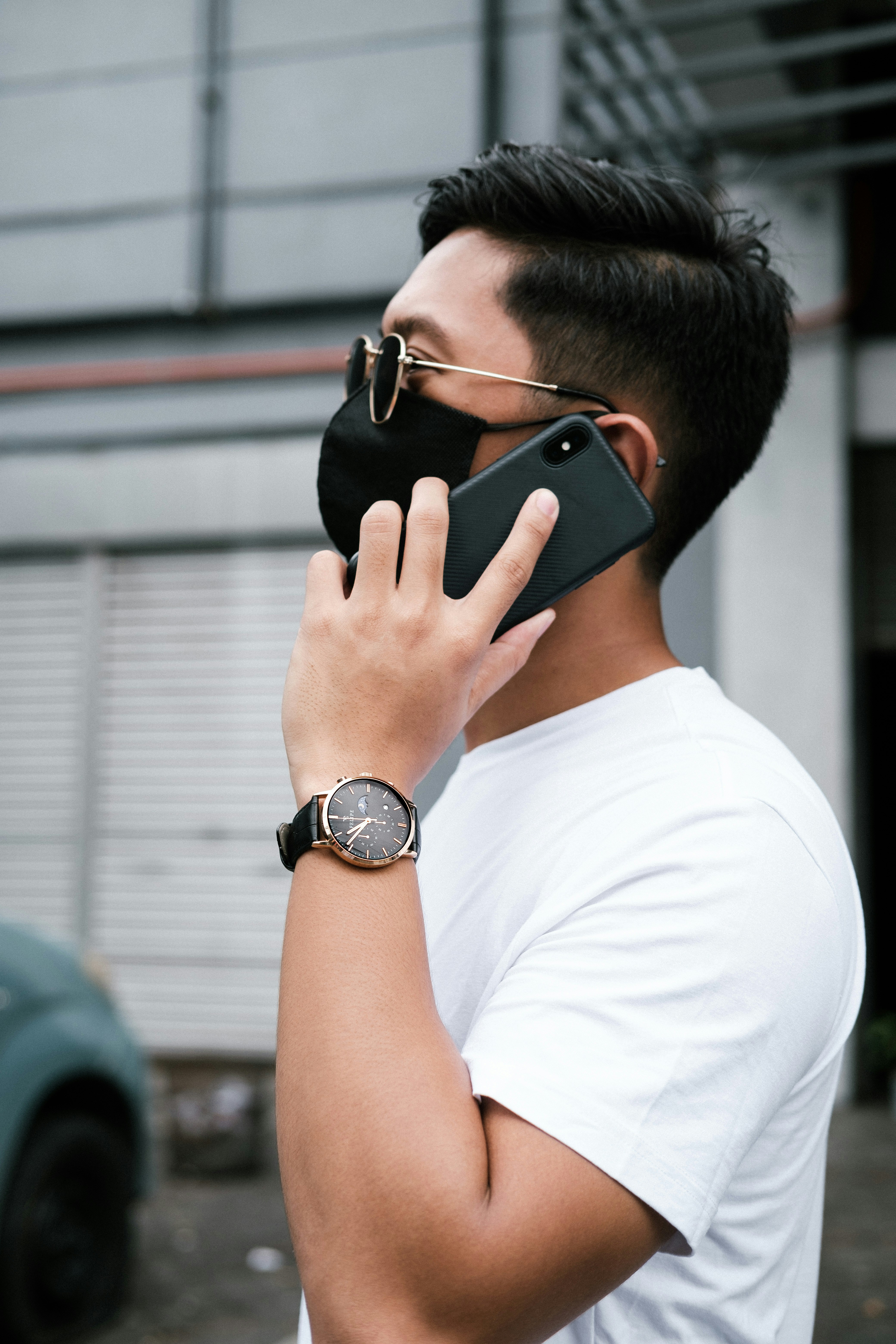 Ein Mann trägt eine Gesichtsmaske, während er auf einem Handy spricht