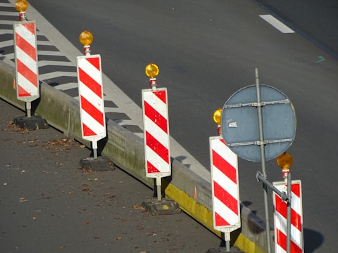 Close-up of reflective warning signs on a moving traffic barrier at night