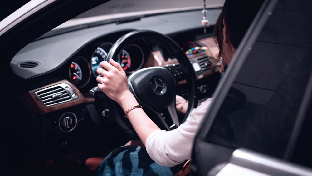 person in blue and white plaid long sleeve shirt driving car