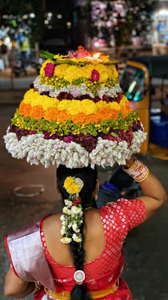person holding white yellow and pink floral cake