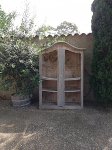 A shoe storage cabinet placed in a garden setting.