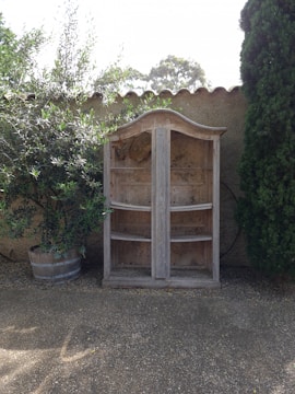 An outdoor shoe storage cabinet displayed in a garden.