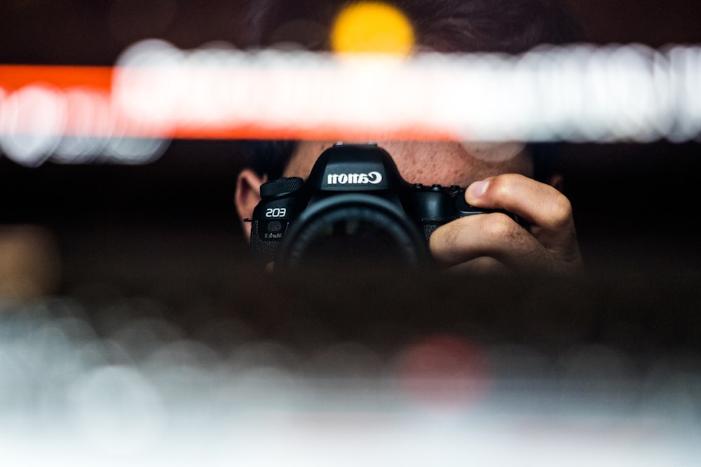 person holding black nikon dslr camera