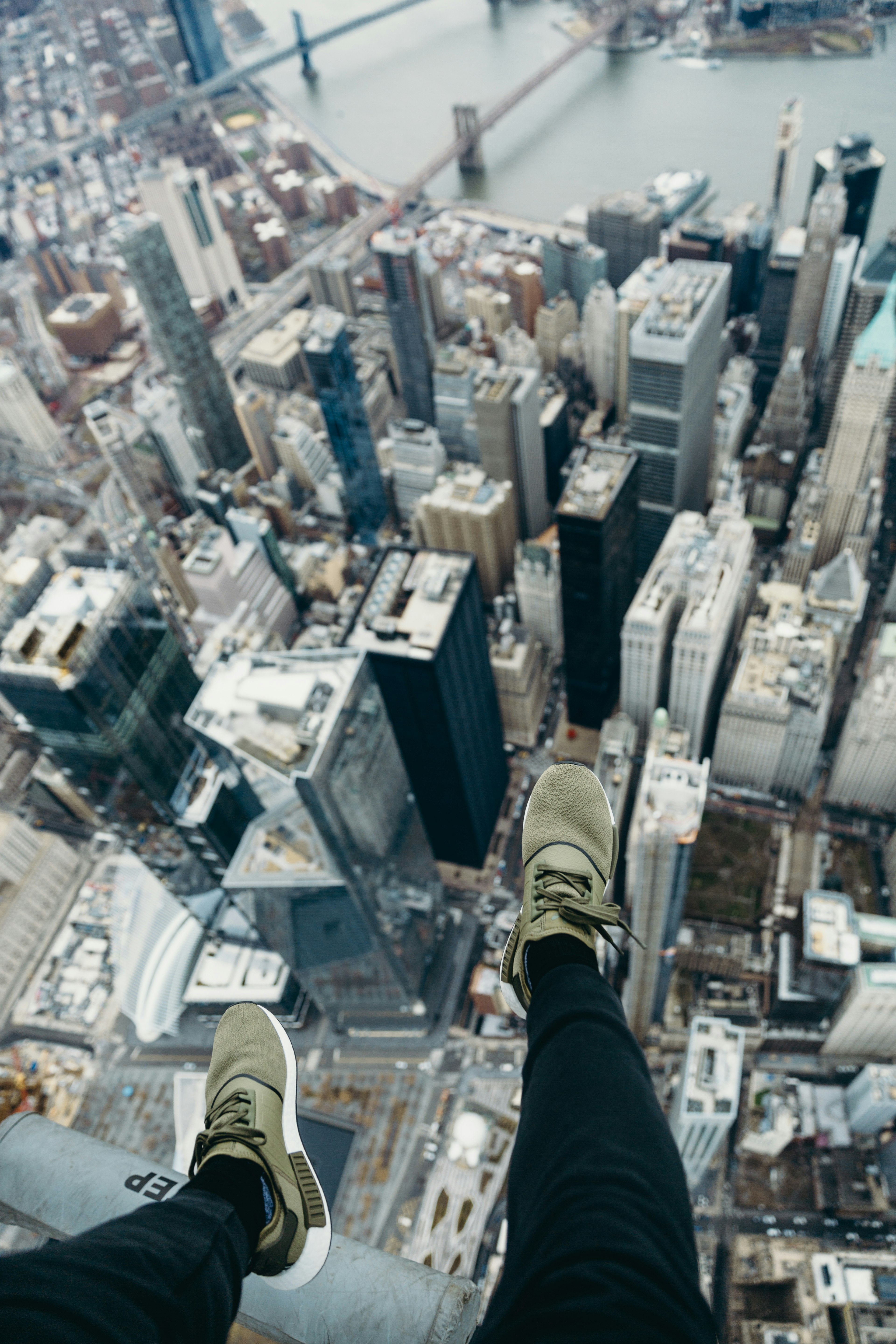 person in black pants and brown shoes standing on top of building