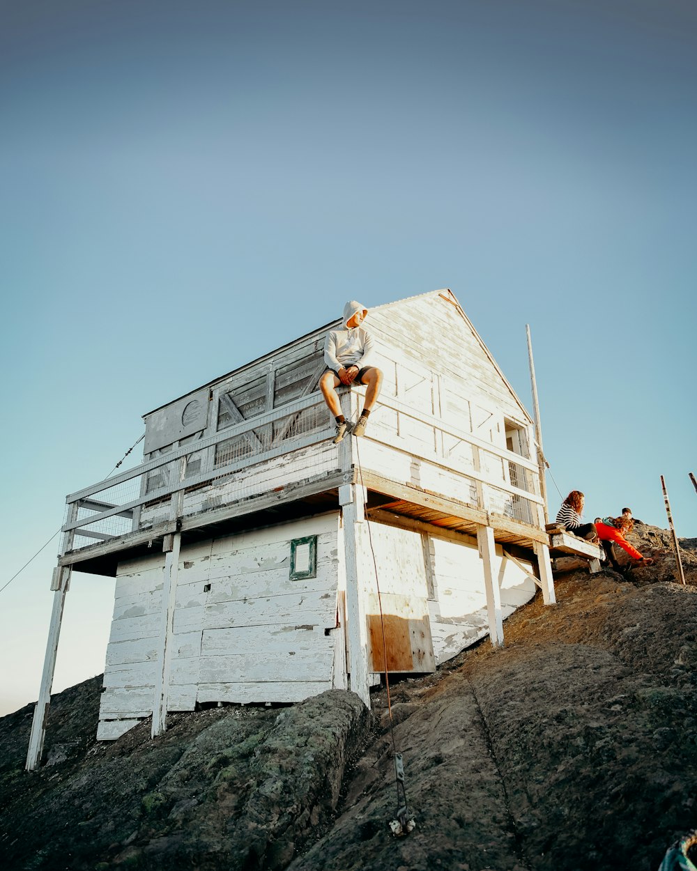 white wooden house on gray rock