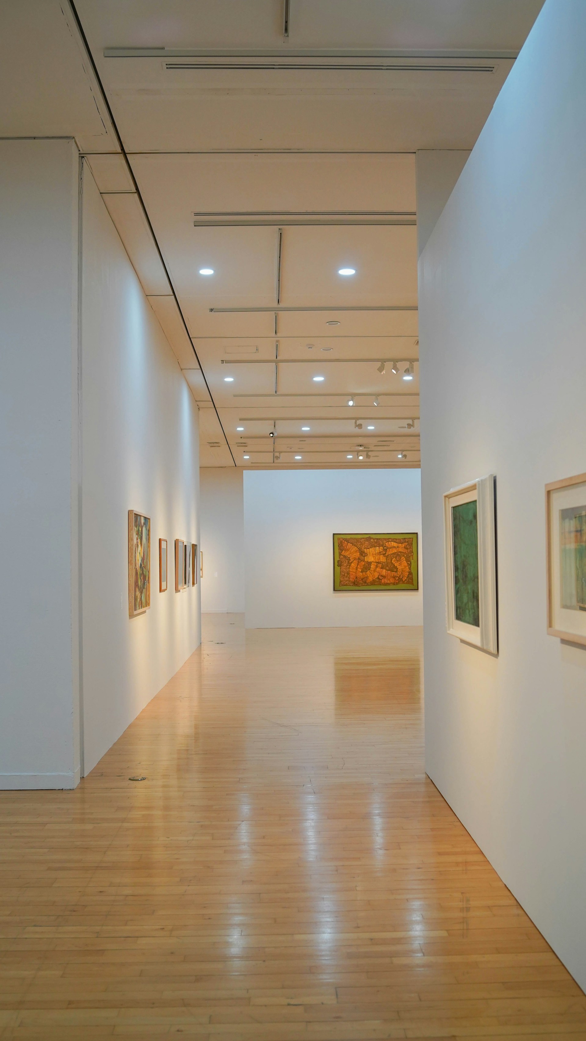 white wall with paintings on wall
