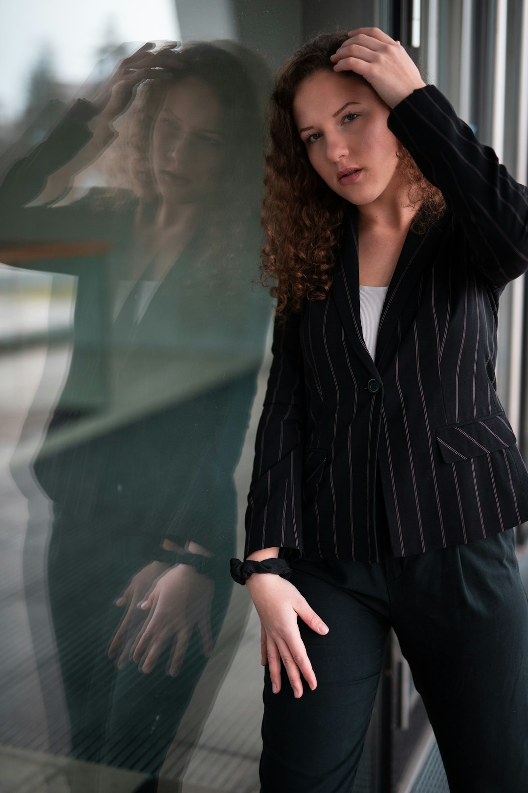 woman in black and white pinstripe blazer standing