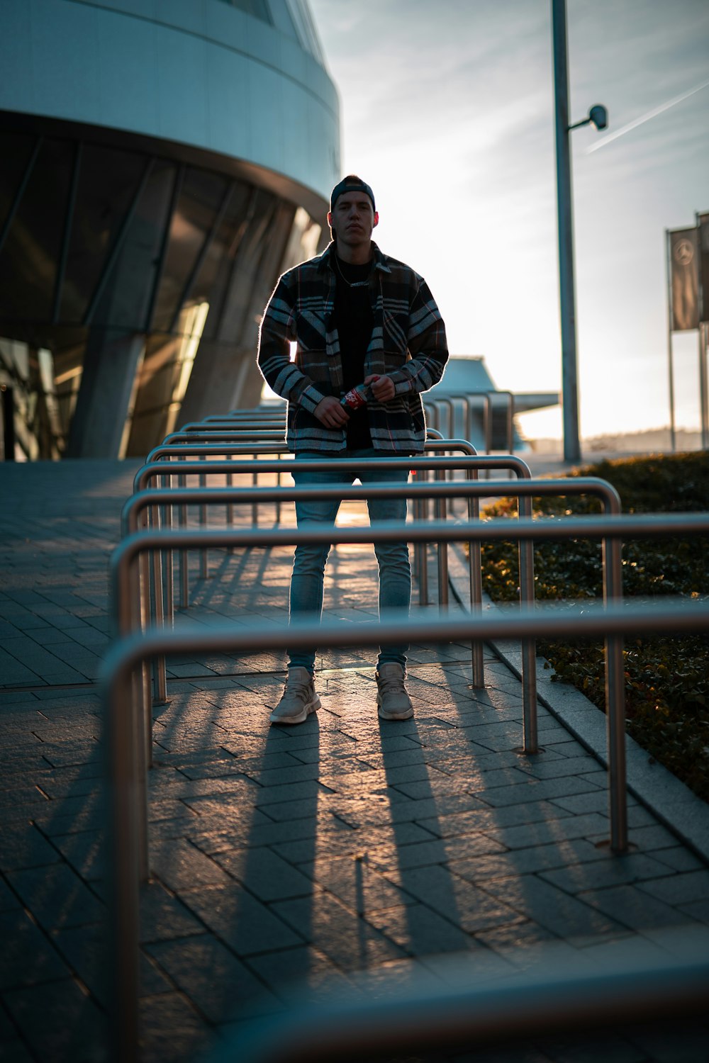 man in black jacket sitting on gray metal railings