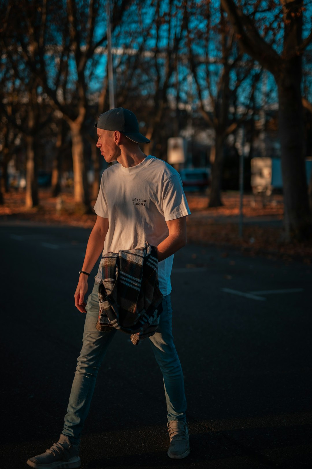 man in white t-shirt and brown pants with black backpack walking on road during daytime