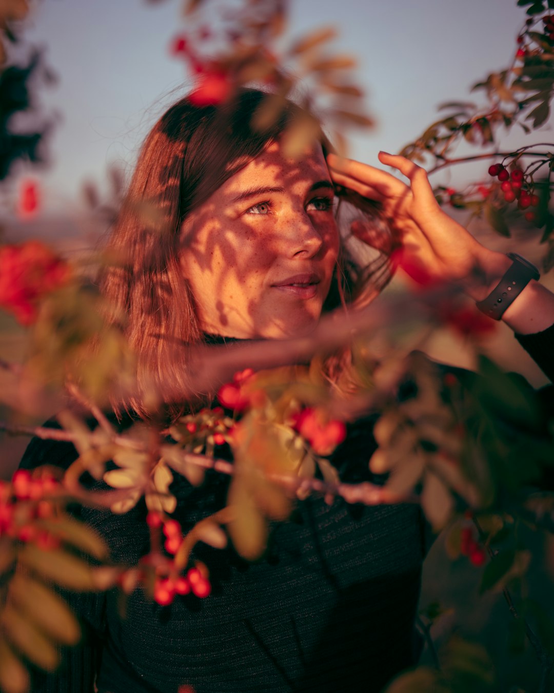 woman in black long sleeve shirt holding red flowers