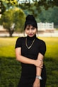 woman in black crew neck t-shirt and black skirt standing on green grass field during