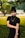 woman in black crew neck t-shirt and black skirt standing on green grass field during