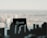 A black rectangular sign with the word 'Renovarde' written on it in white cursive font is placed against a blurred cityscape in the background. The foreground features the silhouette of what appears to be miniature buildings or parts of a city model.