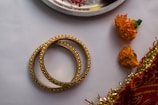 gold and silver bracelet on white table