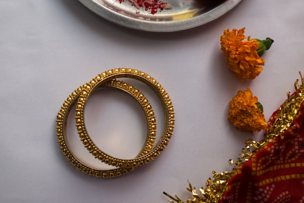 gold and silver bracelet on white table