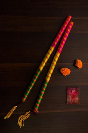 A bundle of vibrant genda (marigold) dhoop batti sticks tied with a traditional thread on a cream-colored fabric.