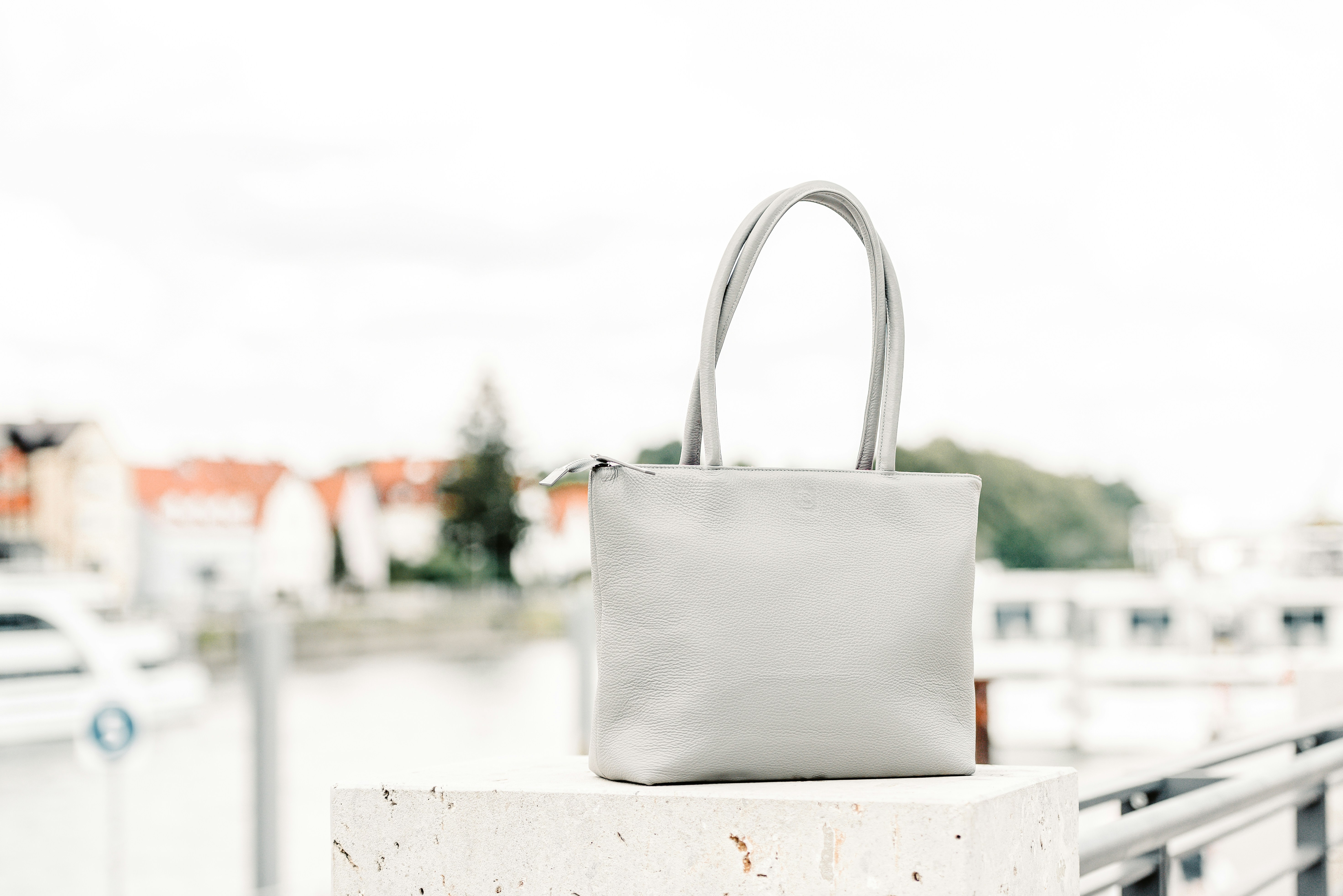 white and brown tote bag on white wooden table