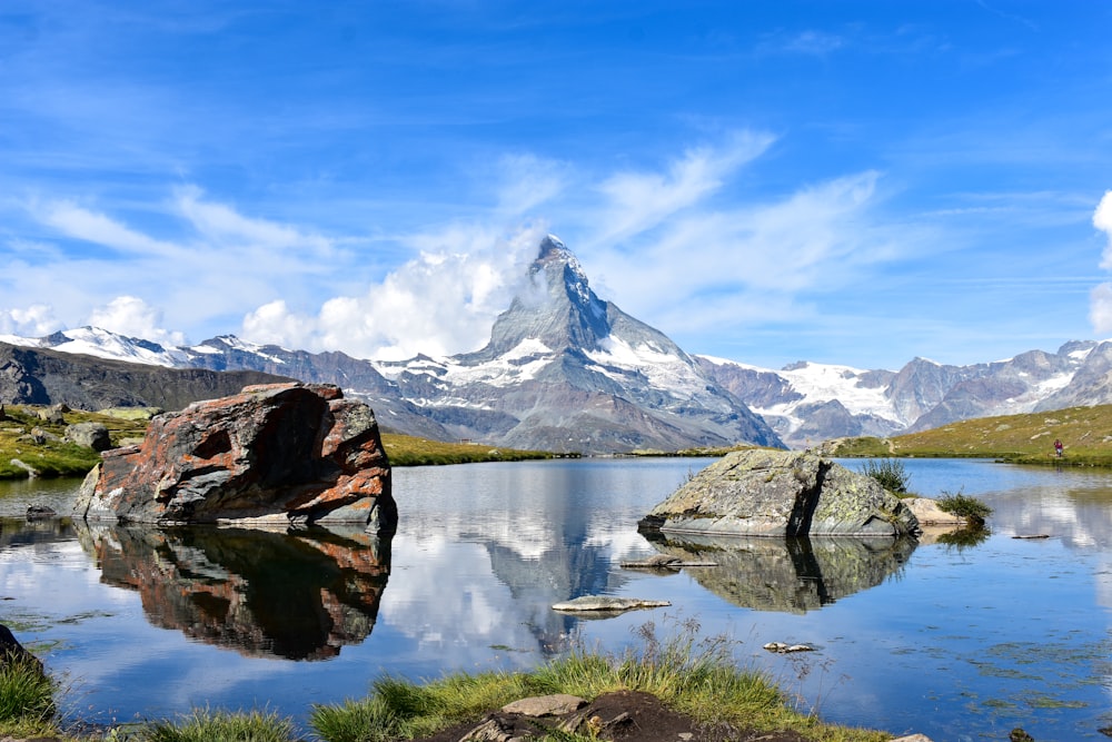 Braune Felsformation in der Nähe des Sees unter blauem Himmel tagsüber