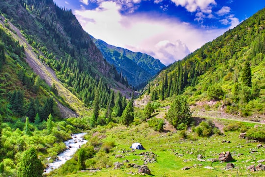 green mountains under blue sky during daytime in Kegeti Kyrgyzstan