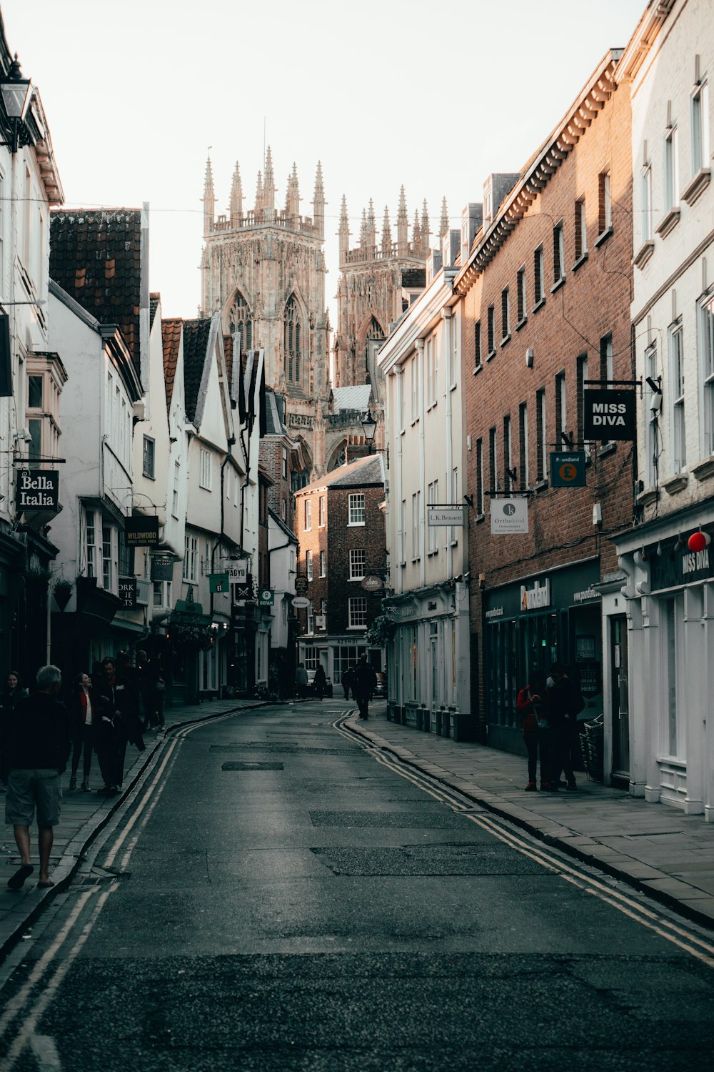 persone che camminano per strada tra gli edifici durante il giorno