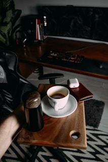 A modern workspace with a laptop, coffee cup, and business documents on a wooden desk.