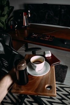 A modern workspace with a laptop, coffee cup, and business documents on a wooden desk.