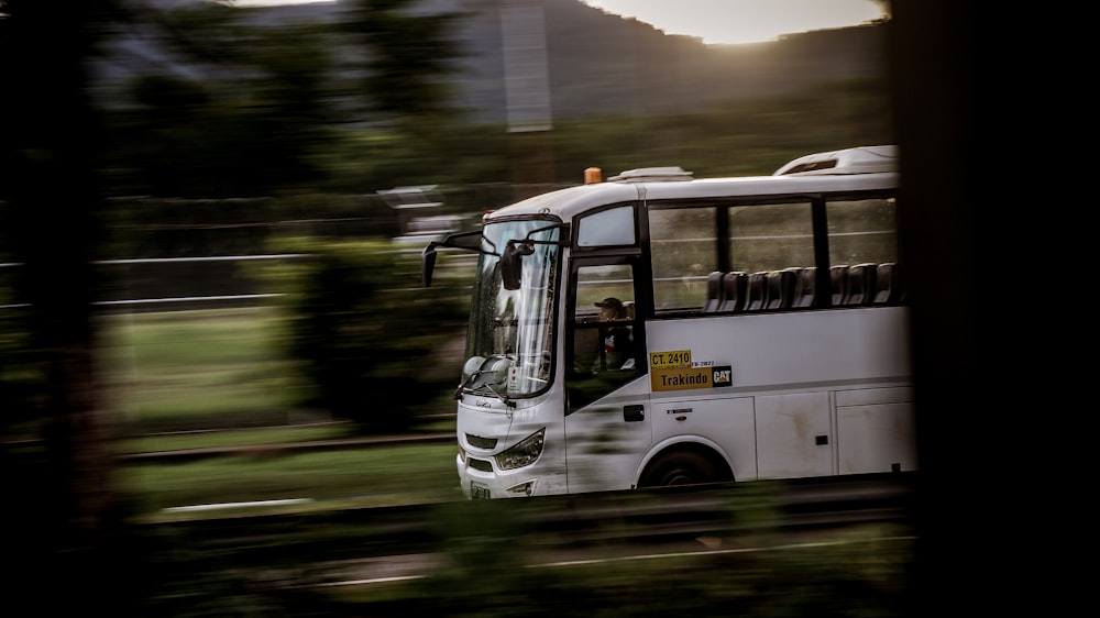 white bus on road during daytime