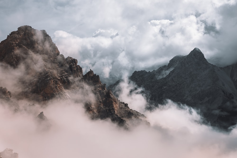 montagne brune et grise sous des nuages blancs