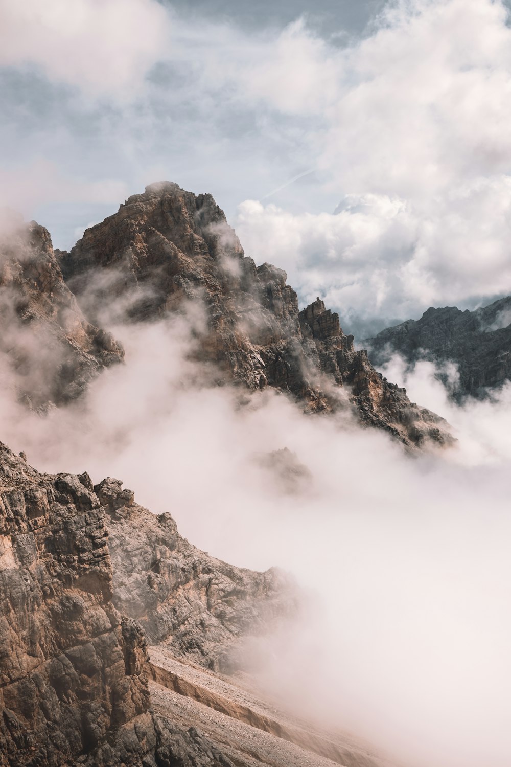 brown rocky mountain covered with clouds