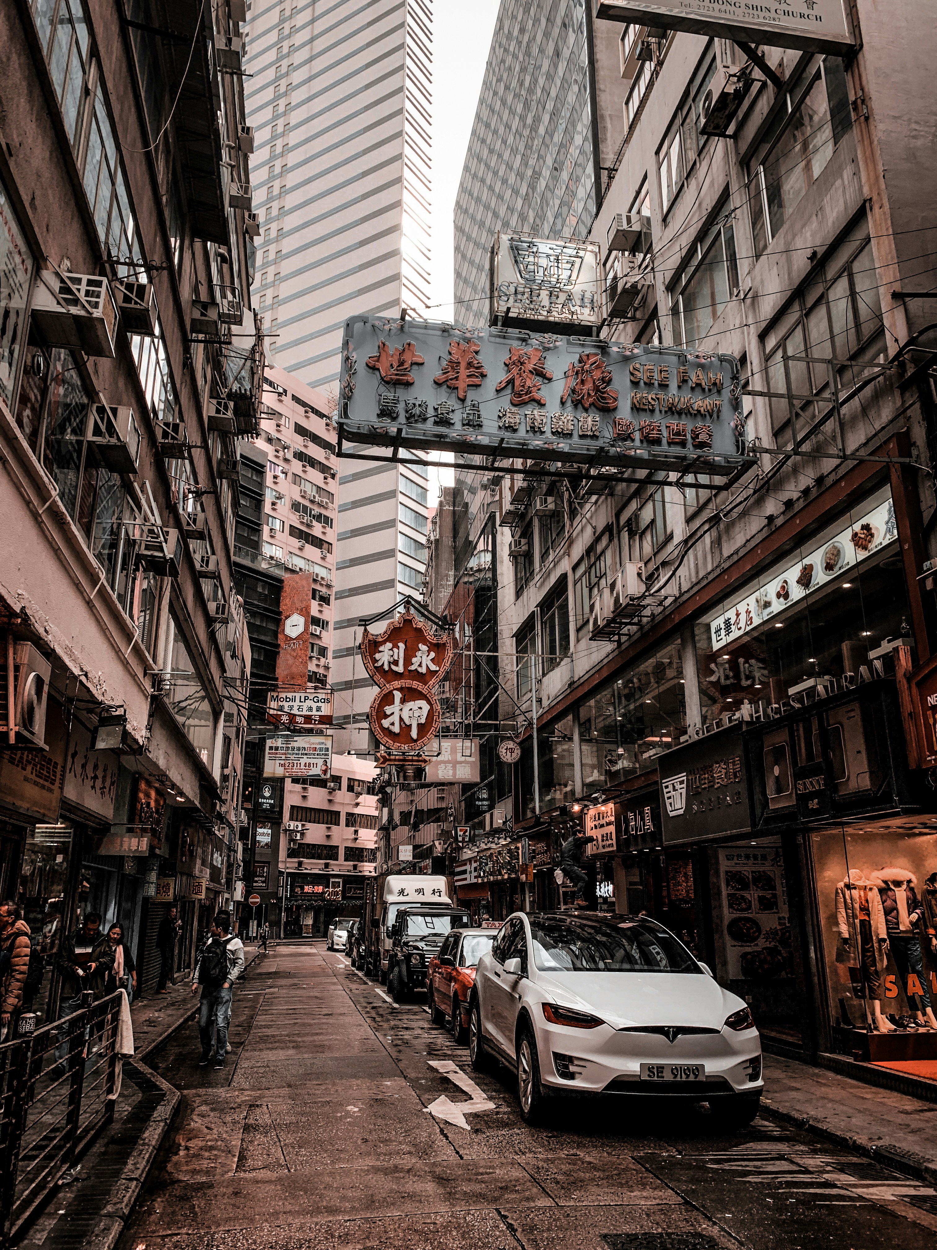 cars parked on street in between buildings during daytime