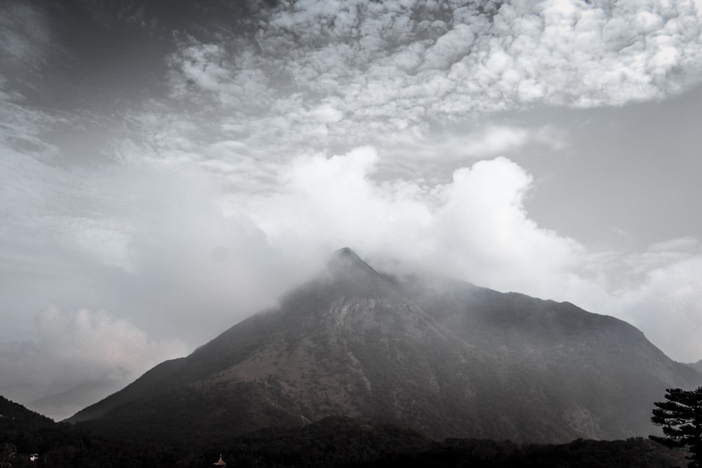 Weiße Wolken über braunem Berg