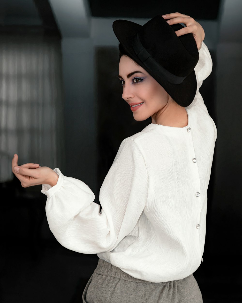 woman in white long sleeve shirt wearing black hat