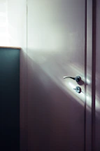 A cozy workspace with a matte black door handle and a striped door curtain softly lit by natural light.