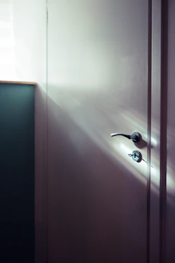 A cozy workspace with a matte black door handle and a striped door curtain softly lit by natural light.